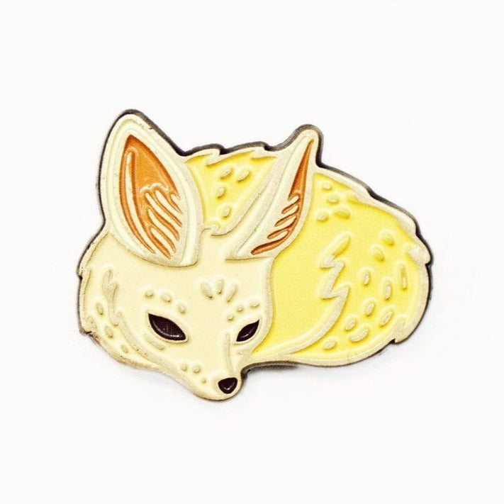 This tiny fennec fox is curled up tight. Light yellow in colour, with a cream coloured face. Its ears are bigger than its head. It has sleepy, almond shaped eyes and a tiny snout.